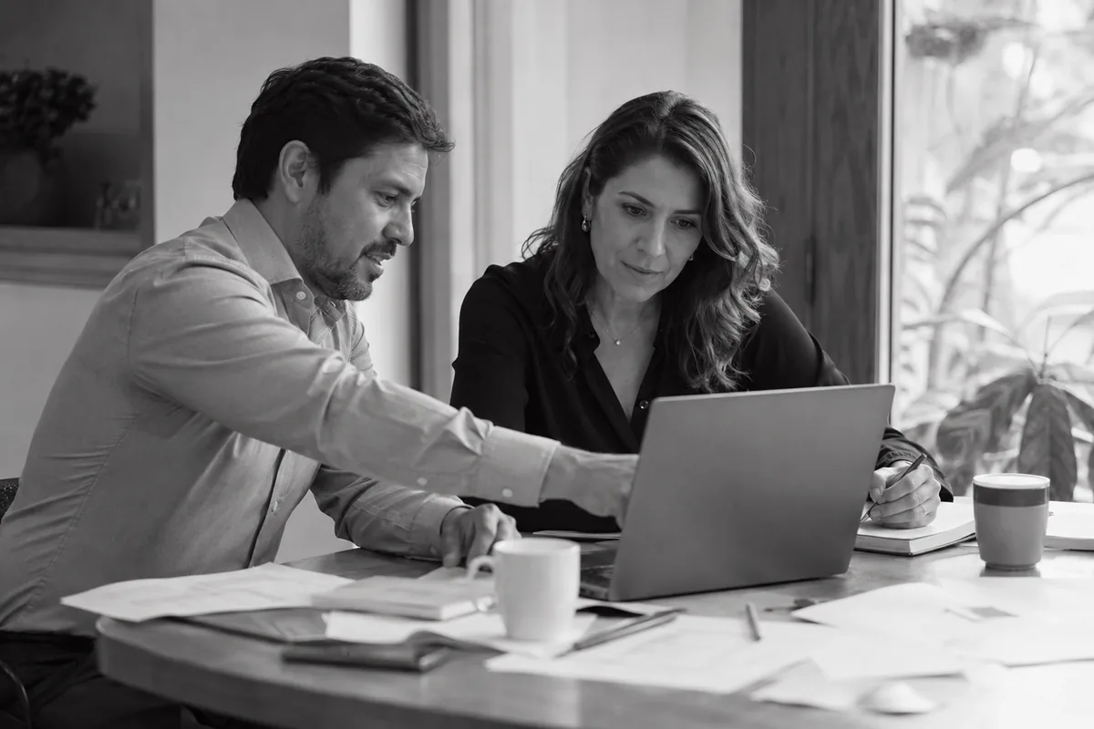 Consultores trabajando en conjunto con laptop